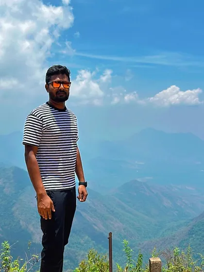 A traveler posing against the backdrop of the Kodaikanal mountains.