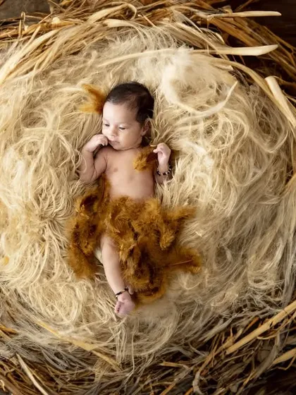 Another perspective of our nest theme, this image shows the newborn nestled in straw-like material. The earthy tones and textures create a wonderfully rustic and organic feel.