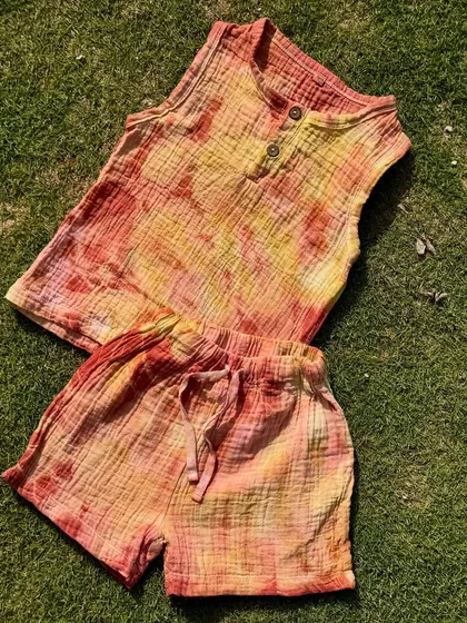 An adorable and summery set of an organic cotton top and shorts for kids. This outfit is hand-dyed with a blend of Indian herbs, making it soft, breathable, and gentle on a child's skin.