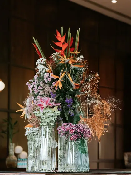 A vibrant and tropical floral arrangement featuring birds of paradise, lilies, and other exotic blooms, setting a fresh and colorful tone for a welcome lunch.