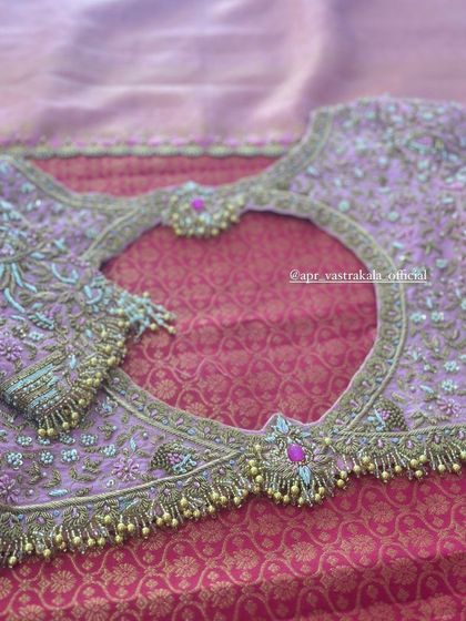 A lavender blouse with a heart-shaped back cutout, framed with heavy embroidery and tassels.