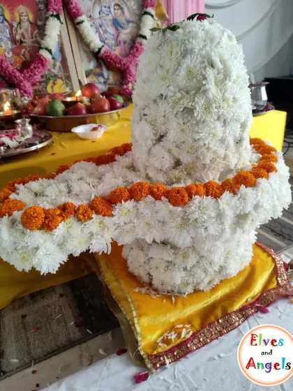 A close-up of the stunning Shivling I created entirely from fresh white flowers, with a marigold garland accent.
