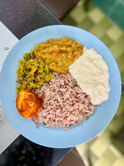 A colorful plate with matta rice, dal, cabbage palya, and a boiled egg. This meal is balanced with complex carbs, protein, and vegetables, showing how simple ingredients can create a nutritious lunch.