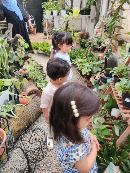 I explore, I learn. We believe the world is the best classroom. Our playgroup children are on a field trip to a local nursery, using all their senses to explore the vibrant flora and learn about nature firsthand.
