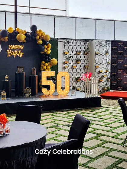 I can handle milestone celebrations for larger groups. This 50th birthday party featured a custom stage with a stylish black and gold backdrop, marquee numbers, and dedicated seating areas for guests, transforming the space into a sophisticated party venue.