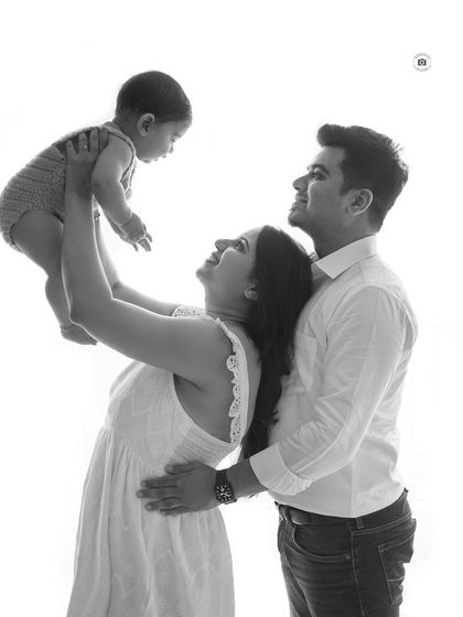 A joyful black and white family photo. Lifting the baby up high always brings out the biggest smiles from everyone.