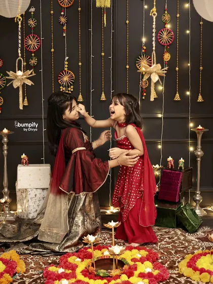 A playful, candid moment between sisters during their Diwali photoshoot. It's these unscripted interactions that truly capture the spirit of family and celebration.