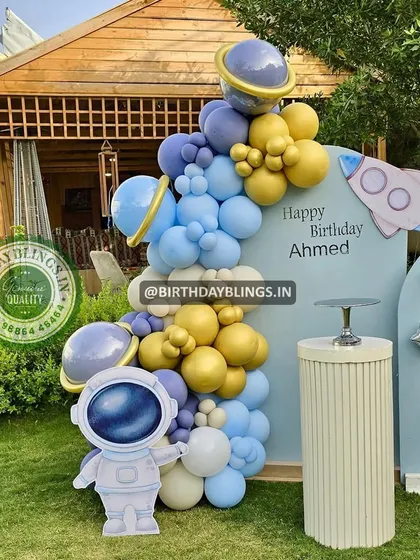 A close-up of the astronaut cutout and the balloon garland, with planets integrated into the arrangement.