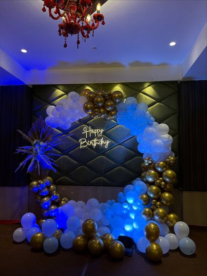 A classic and striking color combination of royal blue, white, and gold. This full ring balloon arch with dramatic uplighting creates a sophisticated and celebratory focal point for any adult party.