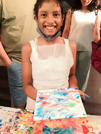 That amazing feeling when you finish your first piece. This young artist is beaming with pride over her colorful fluid art painting.