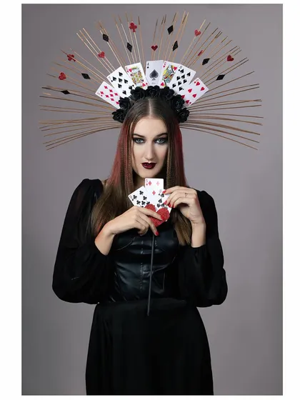A fantasy portrait of a model as a "Queen of Cards," featuring an elaborate headpiece made of playing cards and a dark, regal costume.