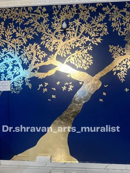 My signature gold foil murals are a true showstopper. Here, a magnificent tree of life spreads its golden branches across a deep blue wall, creating a sense of magic and opulence. This technique catches the light beautifully, making the art feel alive throughout the day.