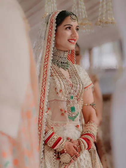 A beautiful portrait of Radhika during her wedding ceremony. Her joyful expression and the intricate details of her bridal jewelry and attire are captured in stunning clarity.
