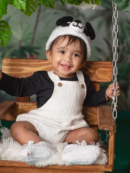 It's not Sunday, it's Panda Day! A happy baby in a panda hat enjoys a swing in our lush, bamboo-filled jungle setup.