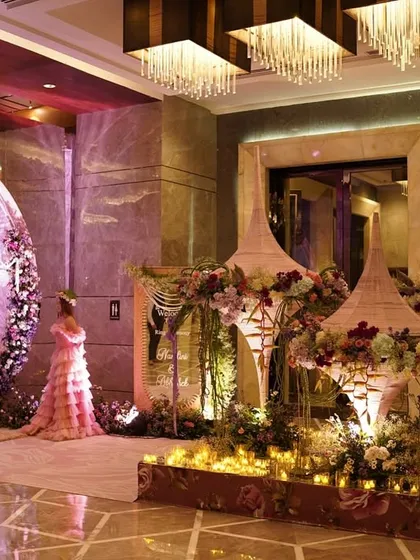 A whimsical welcome for the ring ceremony, featuring handcrafted cone domes, lush florals, and a base of glowing candles, with two hostesses in matching ruffled gowns.