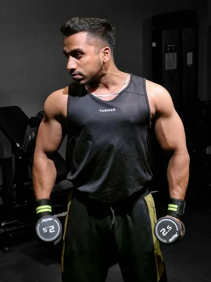 Focused and ready in my gym, Throne Fit. A strong physique is built rep by rep, and here I'm preparing for a bicep workout. This is the kind of focus and intensity we'll bring to every one of your sessions.