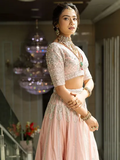 Twirl into a fairytale with this baby pink bridal lehenga. I designed it with intricate horse embroidery on the raw silk skirt and paired it with a heavily handworked blouse and a delicate net dupatta for a truly heavenly look.