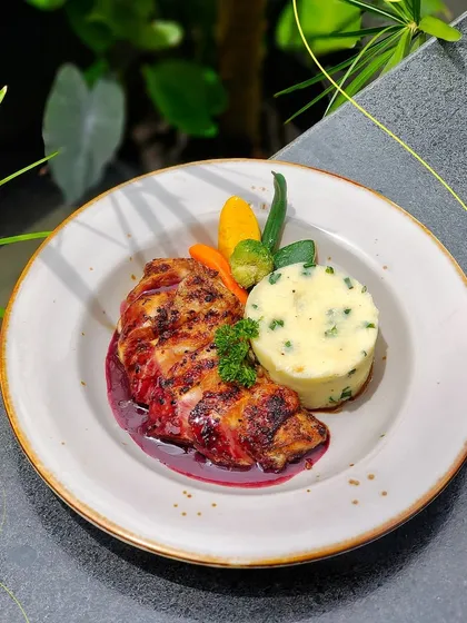 I believe in the comfort of a hearty meal. This plate features a perfectly grilled chicken breast with a rich wine reduction sauce, served alongside creamy mashed potatoes and steamed vegetables.