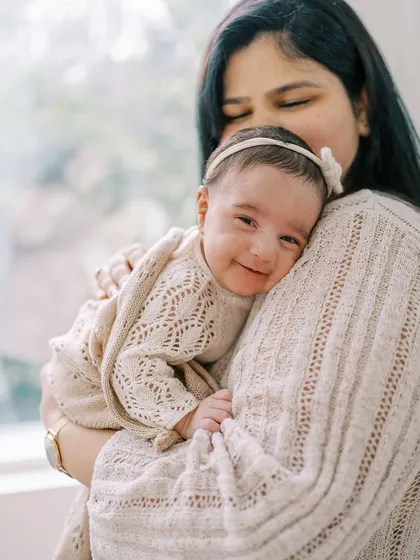 This is the magic I look for. A tiny, perfect smile from a newborn girl, feeling safe and loved in her mother's arms during a gentle, at-home lifestyle session.