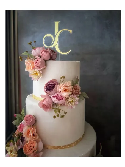 For timeless romance, I craft elegant wedding cakes like this three-tiered beauty. The clean white fondant serves as a perfect canvas for a cascade of handcrafted sugar flowers in soft, romantic hues, finished with a personalized monogram.