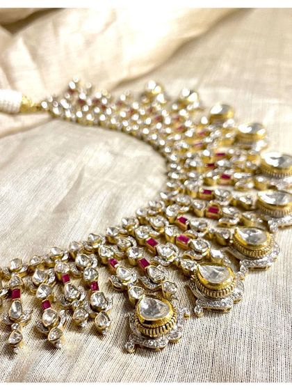 A symphony of diamonds and rubies. This traditional polki necklace showcases intricate craftsmanship, with multiple layers of uncut diamonds accented by deep red rubies.