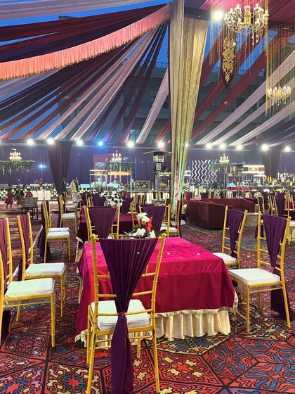 A dining area with a purple and magenta color scheme, showcasing our attention to detail in coordinating tablecloths, chair drapes, and ceiling fabrics.