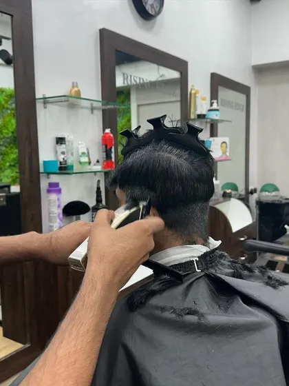 Using the clipper-over-comb technique to achieve a seamless blend in a fade haircut.