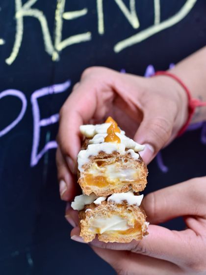 A cross-section of our Lavender & Apricot Eclair. The floral notes of the lavender cream pair beautifully with the sweet and tangy apricot jam.