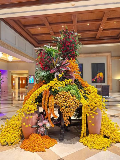 This shot showcases the beautiful contrast between the bright yellow marigolds and the deep red flowers at the top of the installation. The arrangement is a celebration of color and texture.