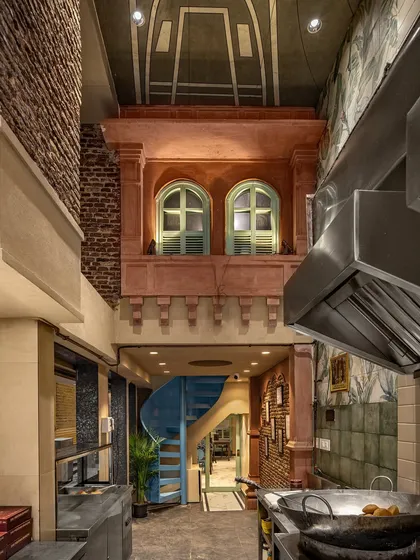 For the Shiv Mishthan Bhandar in Old Delhi, we created a double-height space featuring a traditional jharokha. This design blends heritage aesthetics with modern functional requirements, using craftsmen from Rajasthan to execute the details.