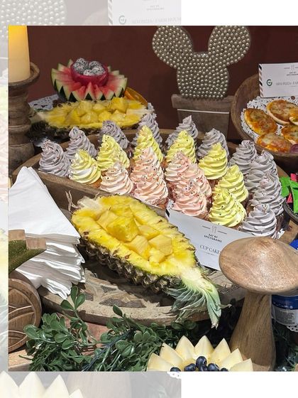 A playful and delicious display for a birthday party, featuring cupcakes with colourful frosting, fresh pineapple, and other fun treats that delight both kids and adults.
