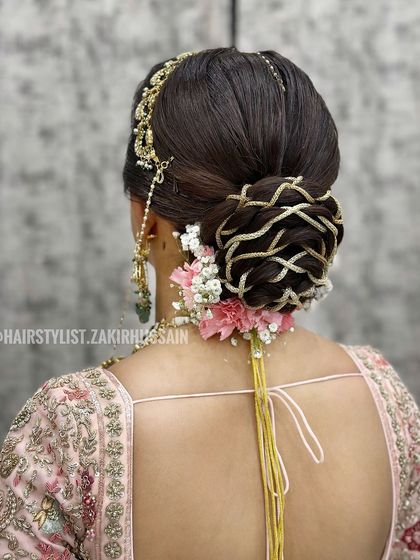 A close-up of the golden thread bridal bun, showing the intricate detail of the weaving. This is a testament to the precise and artistic work I can do.