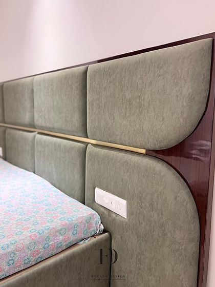 A custom-made bed with a unique headboard design. It combines olive-green upholstered panels with a high-gloss wood frame and a central brass accent, showcasing a sophisticated mix of materials.