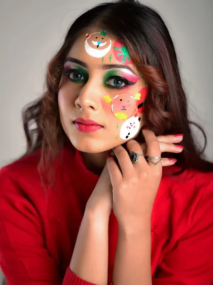 A close-up of the Christmas-themed makeup. You can see the details of the hand-painted Santa and snowman on the model's face, combined with a festive green and red eye look.