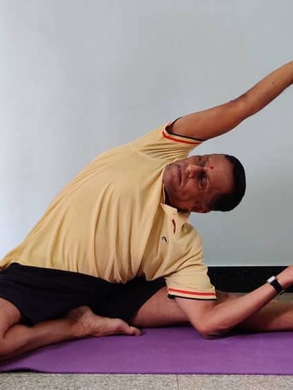 Another stage of Parivrtta Janu Shirshasana with a belt, showing how to work towards the final expression of the pose.