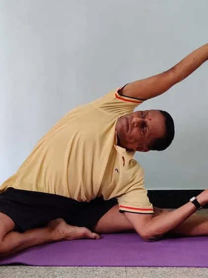 Another stage of Parivrtta Janu Shirshasana with a belt, showing how to work towards the final expression of the pose.