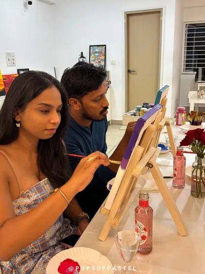 A couple works side-by-side on their canvases, enjoying a unique and romantic Valentine's experience.