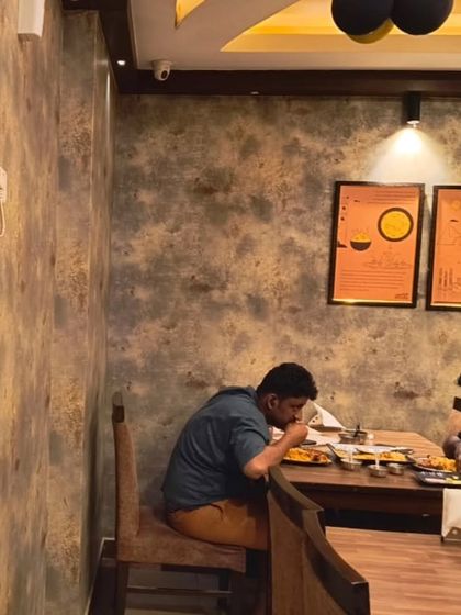 This restaurant interior features a rustic, textured wallpaper that mimics the look of aged or stained concrete. It's an effective way to create a specific theme or ambiance for a commercial space.