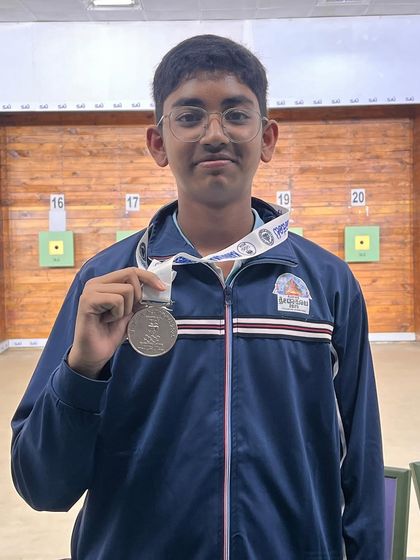A close-up of Satvik with his medal from the 2nd Nagaraj Rao shooting competition, where he won multiple medals in pistol events.