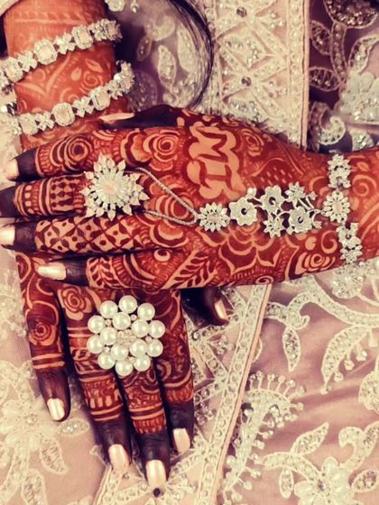 An engagement design with interlocking rings and the initials 'MM', surrounded by floral jewelry.