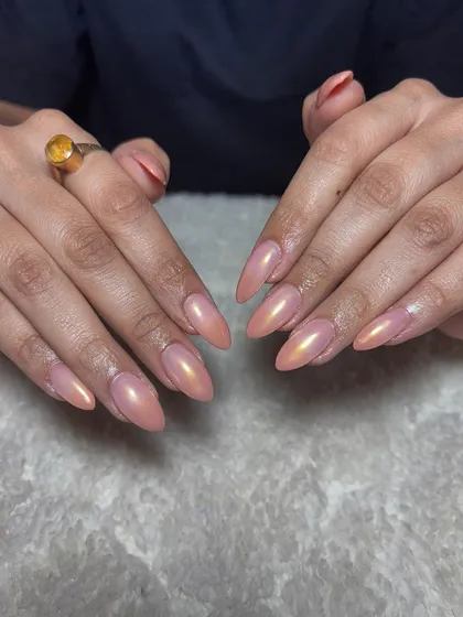 A peachy-nude chrome finish on almond-shaped extensions for a warm, glowing, and sophisticated look.