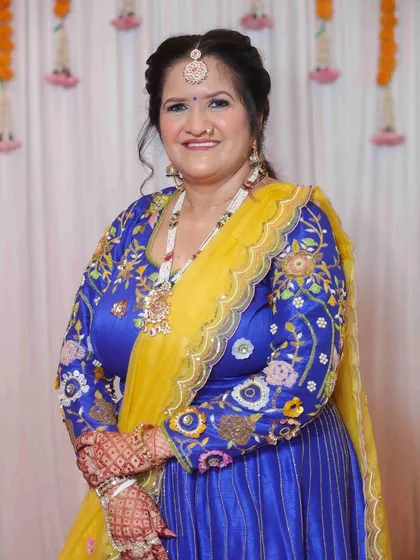 A vibrant and joyful look for a mature client. The makeup is fresh and enhances her features, complementing her bright blue and yellow traditional attire.