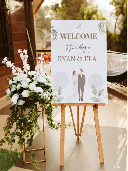 A personalized and illustrated welcome sign for Ryan and Ela's wedding, adding a modern and charming touch to the classic church setting.