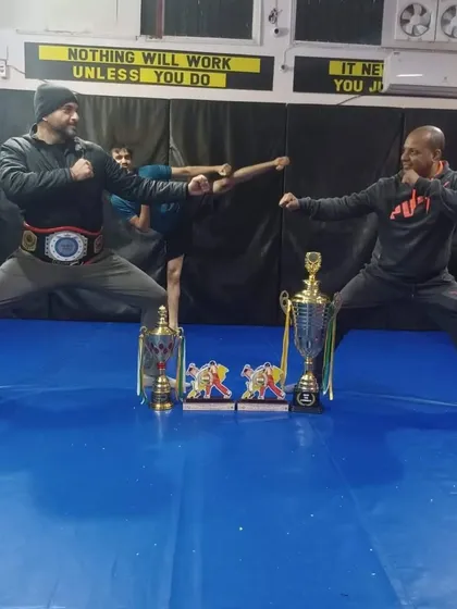 Two generations of fighters, united in strength and discipline. Posing with the championship belt and trophies.