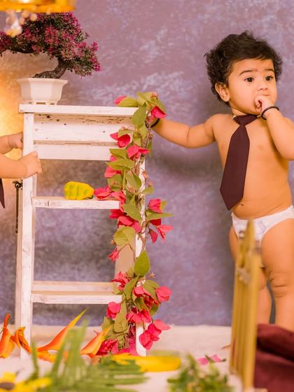A duplicate of image 14, this photo shows another moment of interaction between the twins within the same floral ladder setup, highlighting the potential for capturing different expressions.