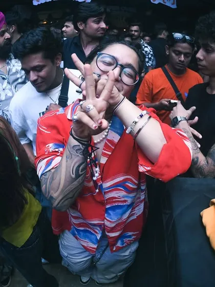 A partygoer showing love to the camera with a peace sign. All good vibes here.