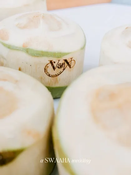 A small, thoughtful detail: coconuts custom-stamped with the couple's wedding monogram, served as a refreshing welcome drink.