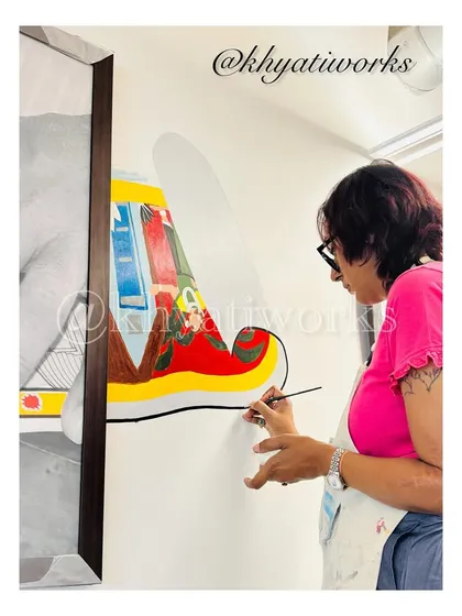 Here I am, focused on painting a colorful, abstract mural for an office space. Each color is carefully chosen to create a vibrant and uplifting atmosphere for the employees.