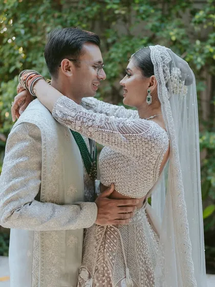 A close-up of the couple's embrace, focusing on their happy expressions and the intimacy of the moment before their beach wedding ceremony.
