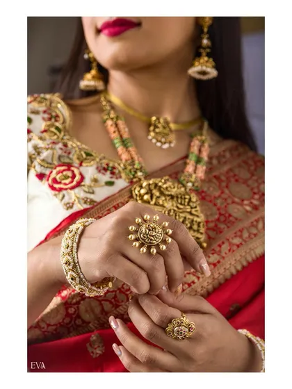 A focused shot on the model's hands, adorned with intricate gold rings and a bangle. This image is perfect for highlighting hand jewellery and accessories in a bridal context.